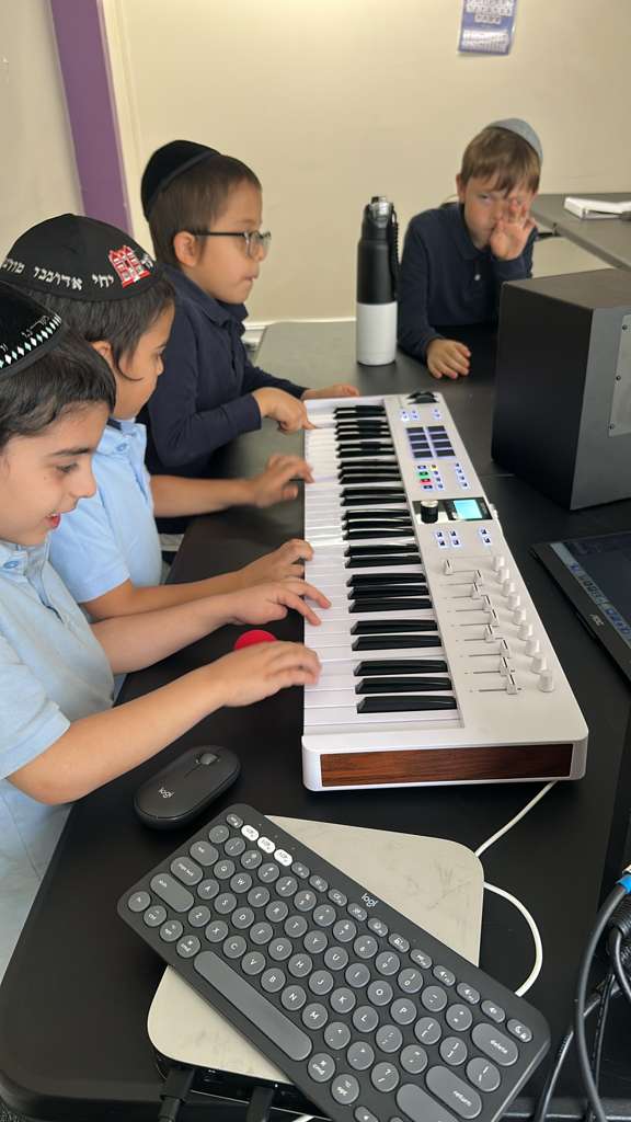 Talmidim learning music on a keyboard